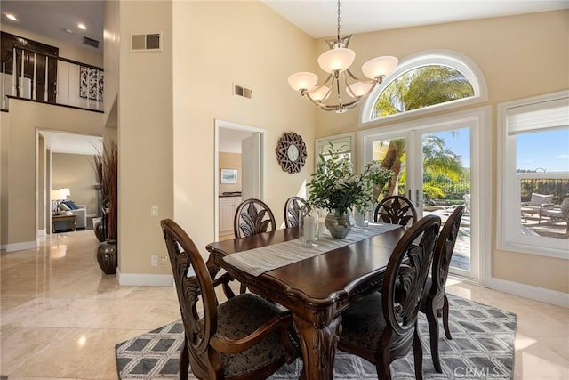 dining space with visible vents, baseboards, a high ceiling, and an inviting chandelier