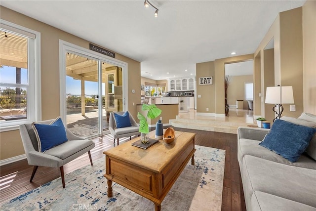 living room with recessed lighting, baseboards, and light wood-type flooring