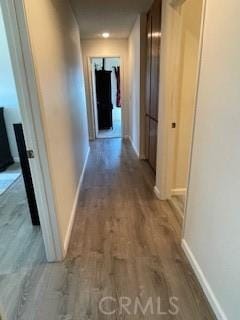 hallway featuring baseboards and wood finished floors