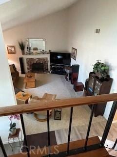 living room with lofted ceiling, a brick fireplace, and visible vents