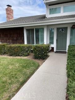 entrance to property with a lawn and a chimney