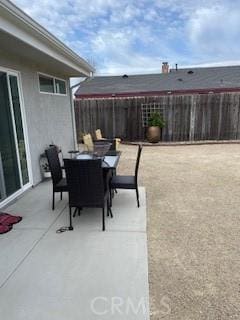 view of patio featuring outdoor dining area and fence