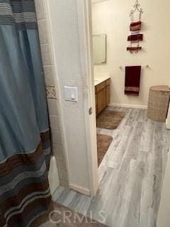 bathroom featuring vanity, a shower with shower curtain, and wood finished floors