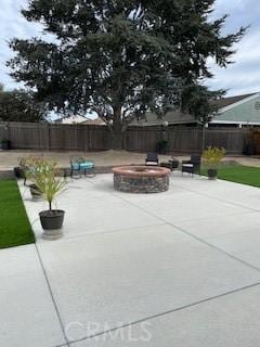 view of patio with a fire pit and fence