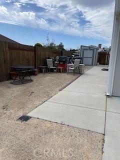 view of patio / terrace with an outbuilding, a shed, and a fenced backyard