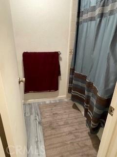 bathroom with a shower with curtain and wood finished floors