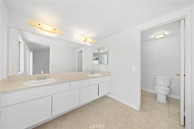 full bath with double vanity, toilet, baseboards, and a sink