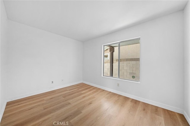 empty room with baseboards and wood finished floors