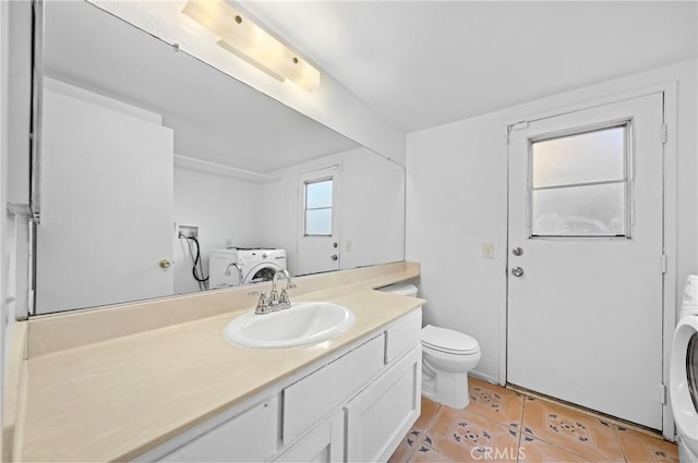 bathroom with tile patterned flooring, washer / dryer, toilet, and vanity