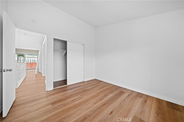 unfurnished bedroom with light wood-style floors and a closet