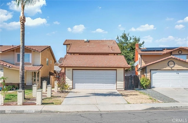 mediterranean / spanish-style home with a tiled roof, a gate, fence, and a garage