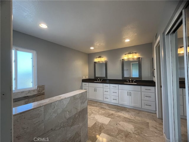 bathroom with a sink, a spacious closet, recessed lighting, and double vanity