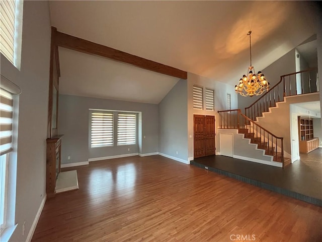 unfurnished living room with beam ceiling, a notable chandelier, stairs, and wood finished floors