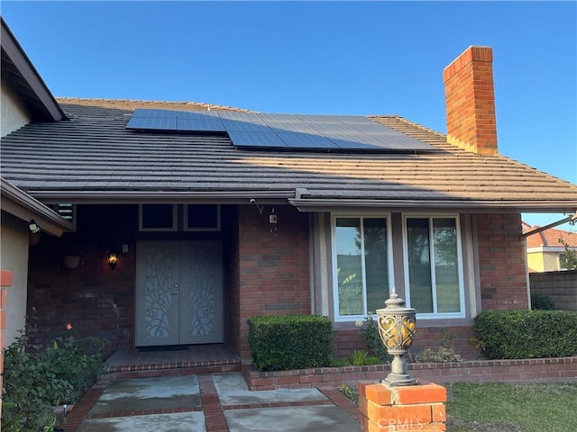 property entrance featuring brick siding and solar panels