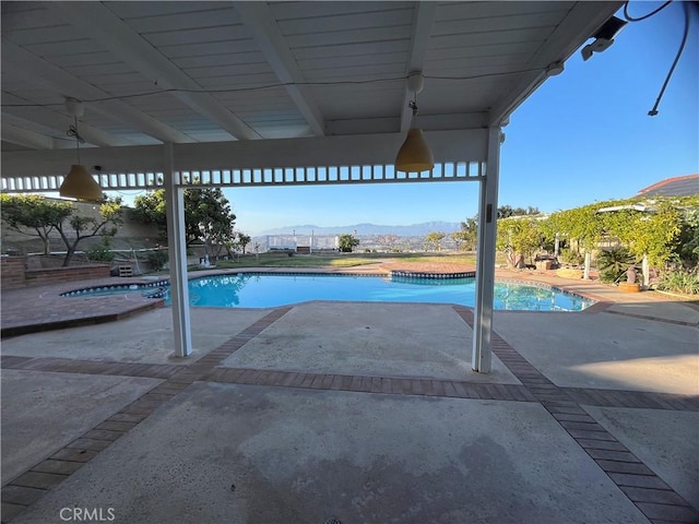 outdoor pool featuring a mountain view, an in ground hot tub, and a patio