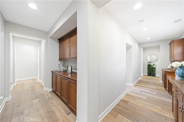 hallway featuring recessed lighting, light wood-style flooring, and baseboards