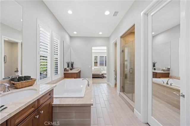 full bathroom with visible vents, a sink, recessed lighting, connected bathroom, and a shower stall