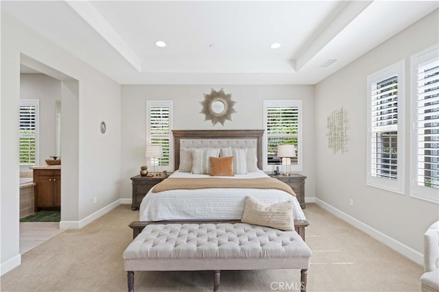 bedroom featuring a raised ceiling, baseboards, and light carpet