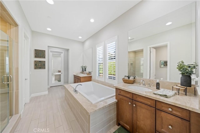 full bath featuring a garden tub, a stall shower, wood finished floors, recessed lighting, and vanity