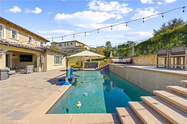 outdoor pool with a patio, area for grilling, and fence