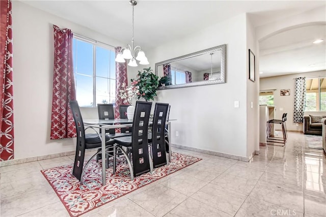 dining space with baseboards and an inviting chandelier