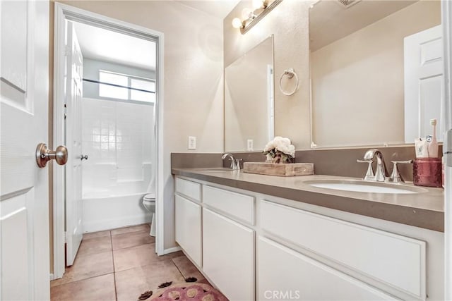 full bathroom featuring tile patterned floors, double vanity, toilet, and a sink