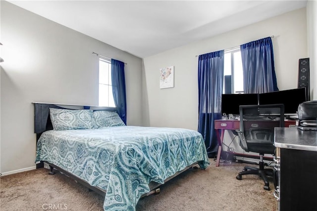 carpeted bedroom featuring multiple windows and baseboards