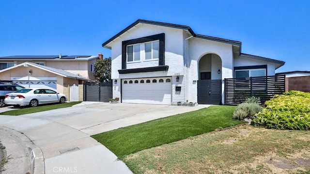 view of front facade with an attached garage, fence, a front yard, stucco siding, and driveway