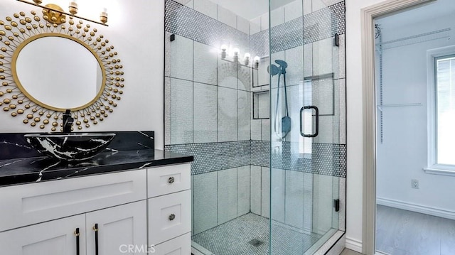 full bathroom featuring vanity, a stall shower, and a wealth of natural light