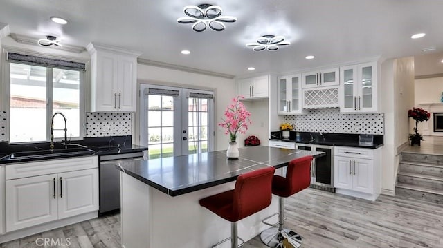 kitchen featuring a sink, dark countertops, wine cooler, white cabinets, and dishwasher