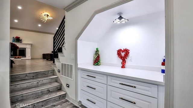 staircase featuring recessed lighting, a fireplace, a ceiling fan, and wood finished floors