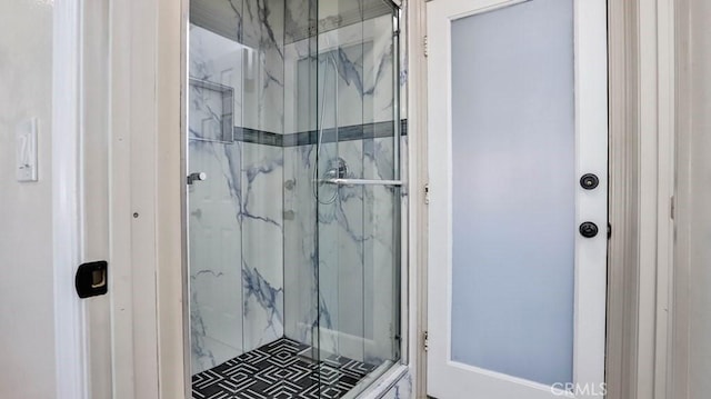 bathroom with a marble finish shower