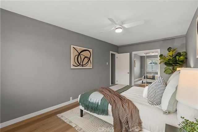 bedroom featuring a ceiling fan, baseboards, and wood finished floors