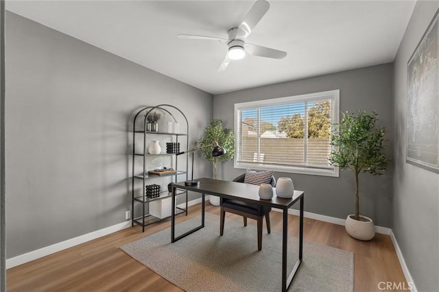 office area with ceiling fan, baseboards, and wood finished floors