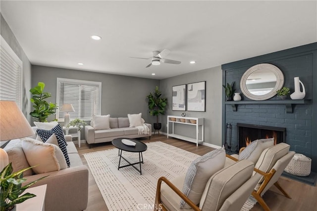 living room with wood finished floors, recessed lighting, a fireplace, and baseboards