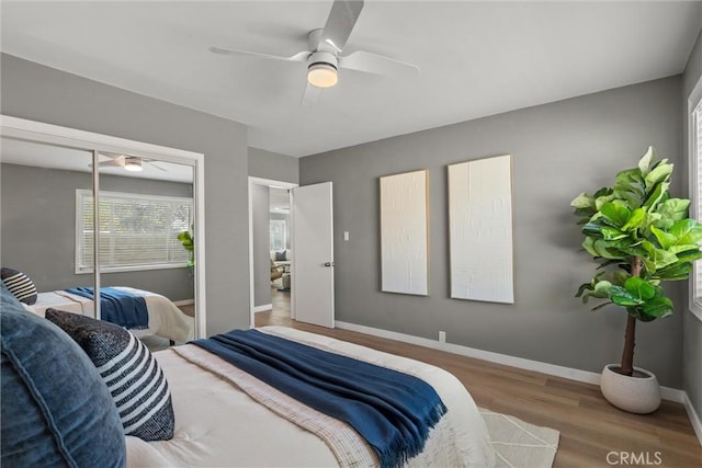 bedroom with a ceiling fan, baseboards, and wood finished floors