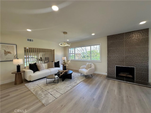 living room featuring recessed lighting, visible vents, baseboards, and wood finished floors