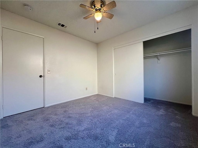 unfurnished bedroom with a closet, visible vents, a ceiling fan, and carpet floors