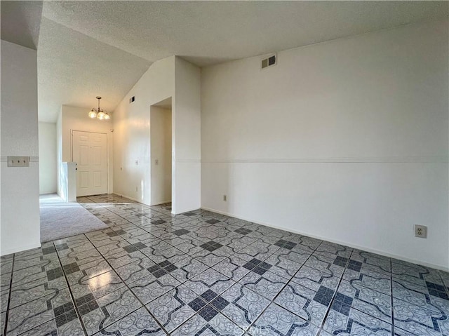 unfurnished room featuring baseboards, visible vents, an inviting chandelier, lofted ceiling, and a textured ceiling