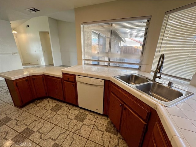 kitchen featuring dishwasher, tile counters, visible vents, and a sink