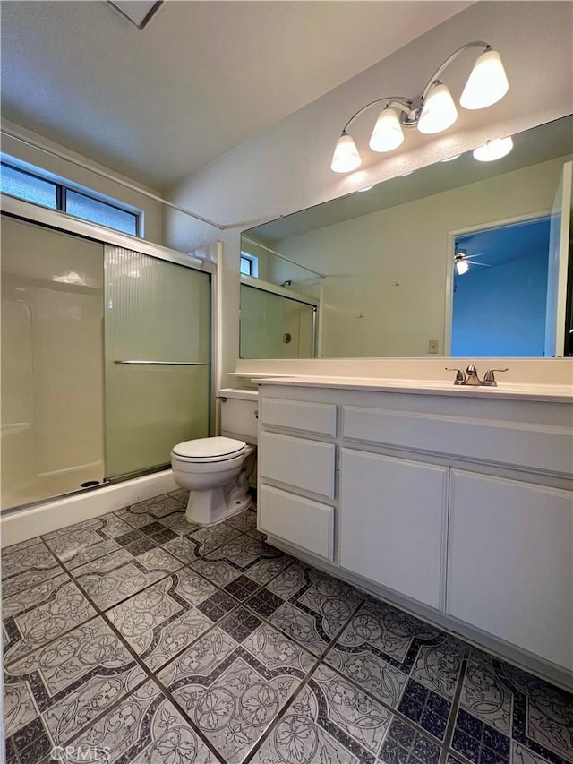 bathroom featuring tile patterned floors, toilet, a stall shower, and vanity