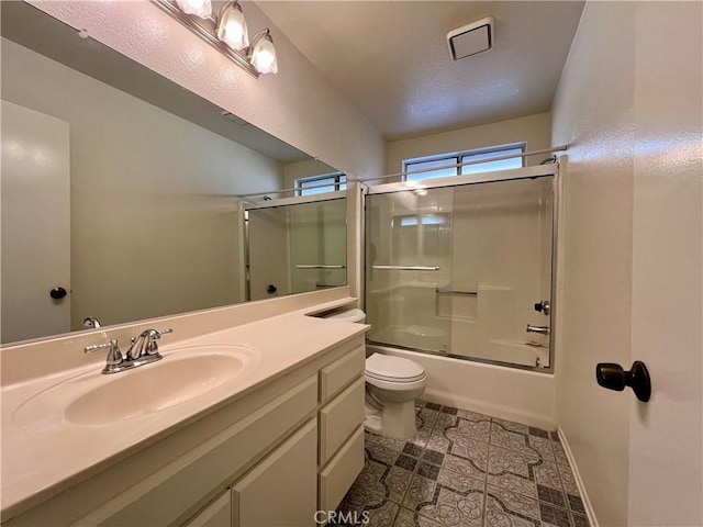 full bath featuring tile patterned floors, toilet, shower / bath combination with glass door, baseboards, and vanity