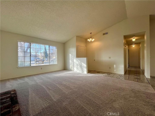 unfurnished living room with carpet, visible vents, an inviting chandelier, vaulted ceiling, and a textured ceiling