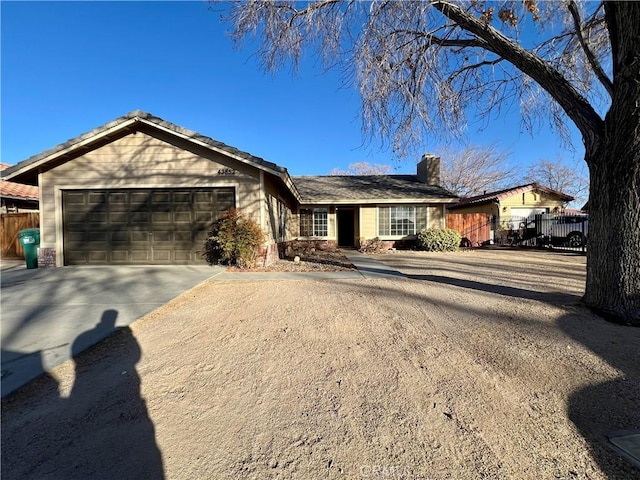 single story home featuring driveway, a chimney, a garage, and fence