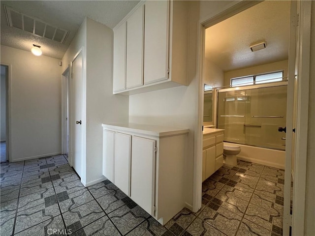 full bathroom featuring visible vents, a textured ceiling, washtub / shower combination, baseboards, and vanity