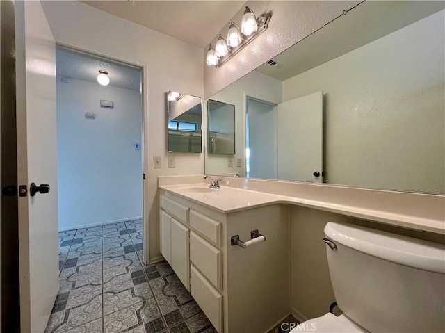 bathroom featuring vanity, toilet, and visible vents