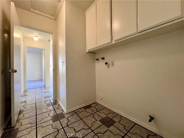 laundry room featuring baseboards, cabinet space, and stone finish floor