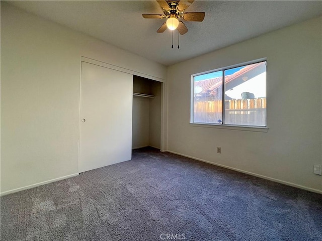 unfurnished bedroom with carpet, a closet, and baseboards