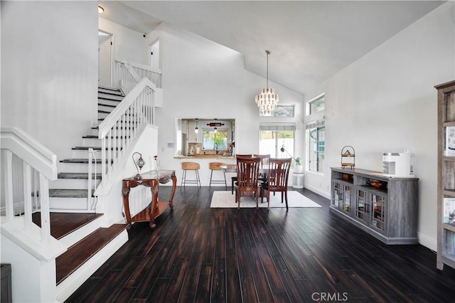 dining room with baseboards, a chandelier, stairs, wood finished floors, and high vaulted ceiling