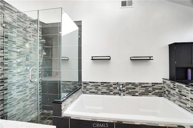 full bath with visible vents, a stall shower, and a garden tub